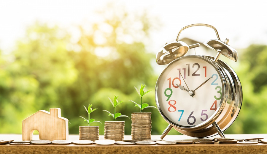 Money stacks with house figure and clock