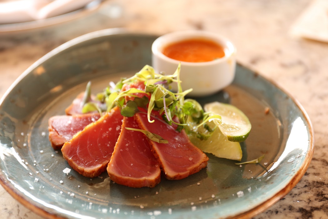 Tuna on a plate with a garnish.