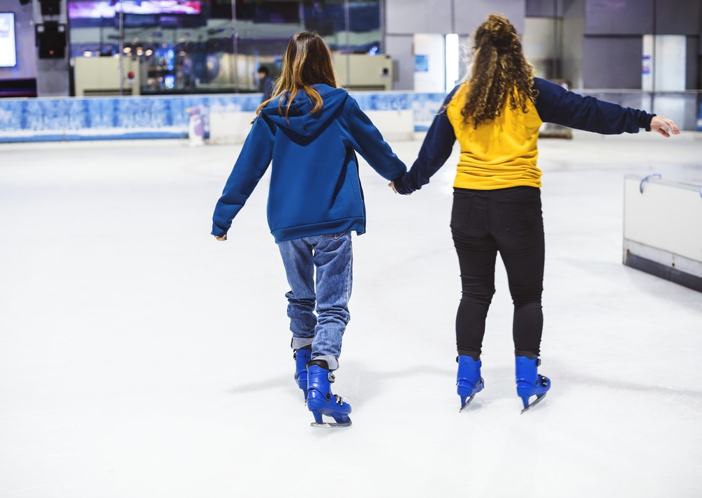 Two girls ice skating at one of the San Francisco holiday events. 